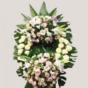 Corona funeral con dos medallones de flores mixtas y filodendro